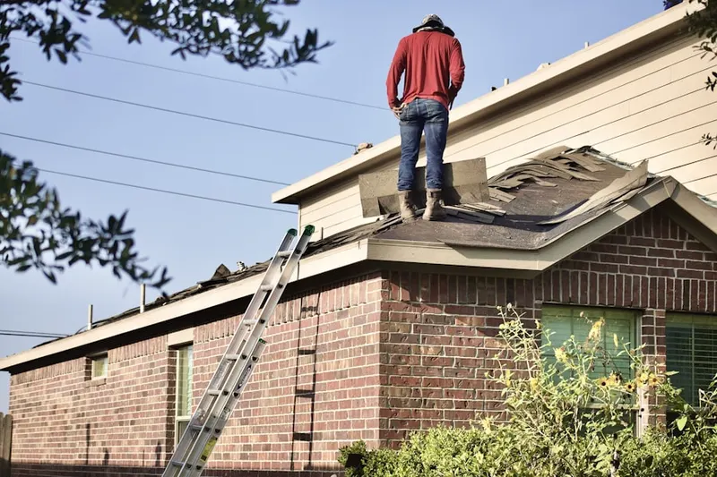 Professional roofer working on a residential roof in Sand Patch